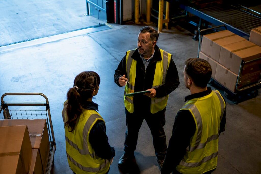 Supervisor leading warehouse workflow change huddle